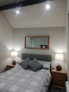 una camera con un letto con due lampade e uno specchio di Sabine Hay Barn a Matlock