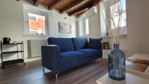 a blue couch in a living room with a vase at Sarpi21 Suites in Udine