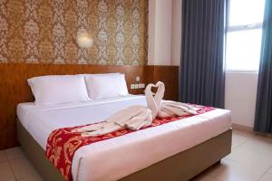 A bed or beds in a room at Marilyn Hotel Serpong