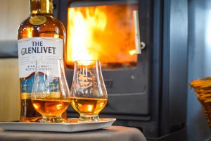a bottle of wine and two glasses on a table at Nova Spero Boat & Breakfast - Caledonian Canal in Fort William +75 photos