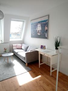 ein Wohnzimmer mit einem Sofa und einem Tisch in der Unterkunft Meer-Harmonie in Kiel