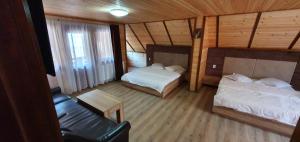 Cette petite chambre comprend deux lits et un canapé. dans l'établissement Pensiune Agroturistică Casa Alex, à Baba