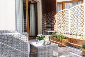 a patio with two wicker chairs and a table at Maloves Resort & Spa Prywatne Apartamenty in Władysławowo