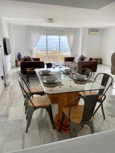 uma sala de estar com uma mesa e cadeiras e um sofá em Puerto Banus Duplex Centric WaterFront 3 Bedroom em Marbella