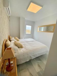 a bedroom with a white bed and a window at Puerto Banus Duplex Centric WaterFront 3 Bedroom in Marbella