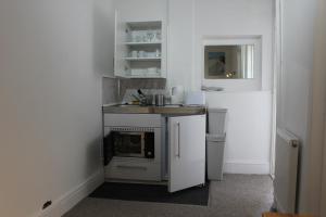 a small kitchen with a sink and a stove at Bayside Holiday Suites in Paignton