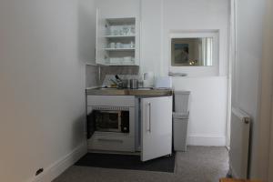 a small kitchen with a sink and a stove at Bayside Holiday Suits in Paignton