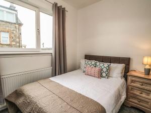 a bedroom with a bed and a window at Annielea is a cosy 3 bed Cottage in Helensburgh in Helensburgh