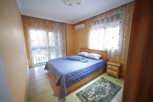 a bedroom with a bed and two windows at Havuz garaj deniz barbekü, 4 oda 3 banyo klimalı villa , Bahçesinde organik meyve sebze sizi bekliyoruz in Didim