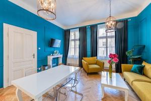 a living room with blue walls and a white table at Colorful Wenceslas square apartment in Prague