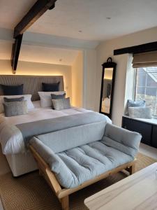 a large bedroom with a large bed and a couch at Half Moon Inn in Sheepwash