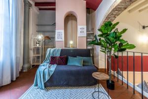 un salon avec un canapé bleu et une plante dans l'établissement Wine Apartments Florence Vernaccia, à Florence