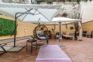 une terrasse avec un parasol blanc, des chaises et un tapis dans l'établissement Wine Apartments Florence Vernaccia, à Florence