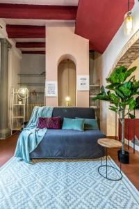 un salon avec un canapé bleu et un tapis dans l'établissement Wine Apartments Florence Vernaccia, à Florence