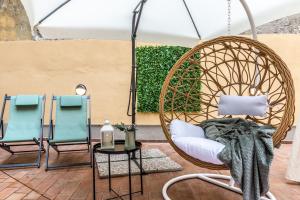 a porch with two chairs and a swing at Wine Apartments Florence Vernaccia in Florence