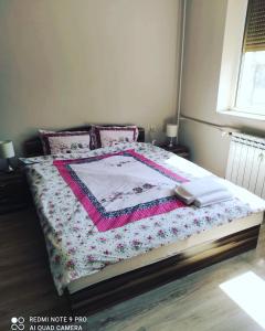 a bedroom with a bed with a quilt on it at Pleven Sunny Apartment in Pleven