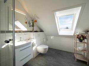 een badkamer met een wastafel, een toilet en een raam bij Tom's Hus Heiligenhafen in Heiligenhafen