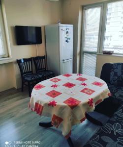 a room with a table with a red and white quilt at Pleven Sunny Apartment in Pleven
