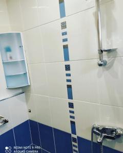 Łazienka wyłożona jest niebieskimi i białymi kafelkami oraz umywalką. w obiekcie Pleven Sunny Apartment w mieście Plewen