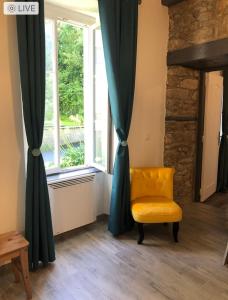 a yellow chair sitting in front of a window at residence fleurie rdc in Saint Malo