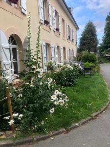 a building with flowers in the grass next to a building at residence fleurie rdc in Saint Malo