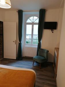 een slaapkamer met een bed, een raam en een stoel bij residence fleurie rdc in Saint-Malo