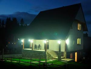 a house with a porch at night with lights at Hostel Highlander in Žabljak