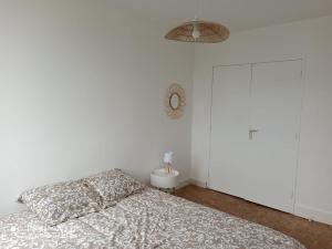 a bedroom with a bed and a clock on the wall at Superbe appartement tout équipé proche Hypercentre in Bergerac