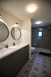 ein Badezimmer mit einem Waschbecken, einem WC und einem Spiegel in der Unterkunft The lodge Morris in Löwen