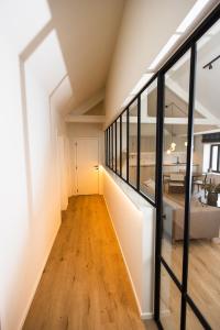 a hallway of a house with glass walls and wooden floors at The lodge Morris in Leuven