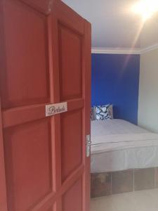 uma porta vermelha com uma cama num quarto em Bophelo Guest House @ Pella em Ga-Mathako