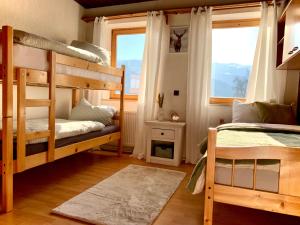 a bedroom with two bunk beds and a window at Ferienhaus mit Zirbitzblick in Mönchegg