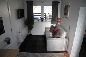a living room with a chair and a window at The Wee Bank House in Oban