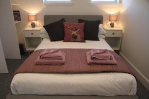 a bedroom with a bed with a deer head pillow at The Wee Bank House in Oban