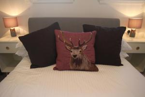 a picture of a deer pillow on a bed at The Wee Bank House in Oban
