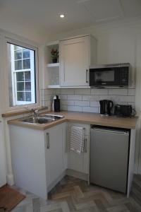 uma cozinha com um lavatório e um micro-ondas em The Wee Bank House em Oban
