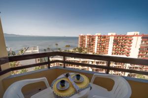 balcón con 2 sillas y vistas al océano en Hotel Apartamentos Londres La Manga en La Manga del Mar Menor