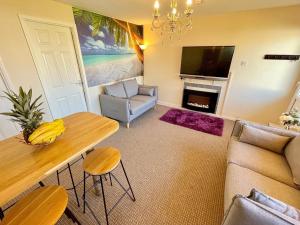 a living room with a couch and a table at Paradaise Immaculate 2-bed property Hemsby in Hemsby