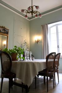a dining room table with a white table cloth and chairs at B&B Coup de Coeur in Bram