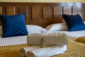 a pile of towels sitting on top of a bed at Hotel Apartamentos Londres La Manga in La Manga del Mar Menor