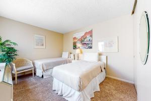 a hotel room with two beds and a chair at Palm Springs Condo, Sunrise Villas in Palm Springs