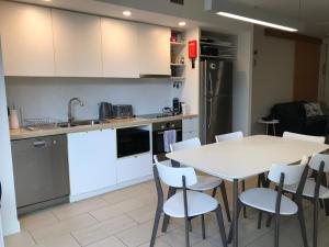 - une cuisine avec une table blanche et des chaises blanches dans l'établissement Euodia Unit 1102, à Nelly Bay