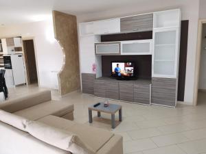 sala de estar con sofá y TV en APPARTAMENTO FALCO, en Mercogliano