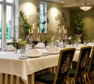 a dining room with a table with white table cloth and chairs at Losby Gods Manor in Lorenskog