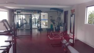 a gym with treadmills and machines in a room at Park Towers in Natal