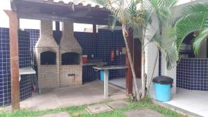 an outdoor grill with a picnic table and a palm tree at Park Towers in Natal