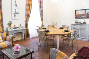ein Esszimmer mit einem Tisch und Stühlen in der Unterkunft Appartamento Salimbeni in Siena