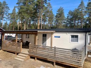 een tiny house met een veranda en een terras bij Karlstad Swecamp Bomstadbaden in Karlstad