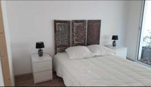 een slaapkamer met een bed met twee nachtkastjes en twee lampen bij Entre terre et mer in Pornic