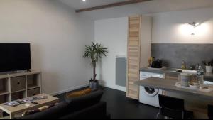 een woonkamer met een tafel en een keuken bij Entre terre et mer in Pornic